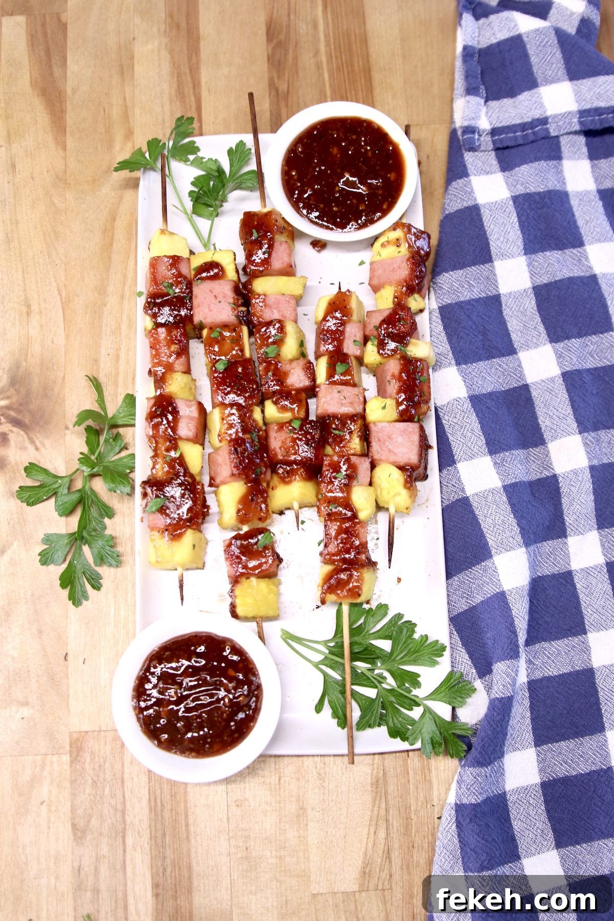 Easy appetizer - grilled spam skewers with pineapple chunks overhead of platter of kabobs with spam and pineapple, bowls of bbq sauce
