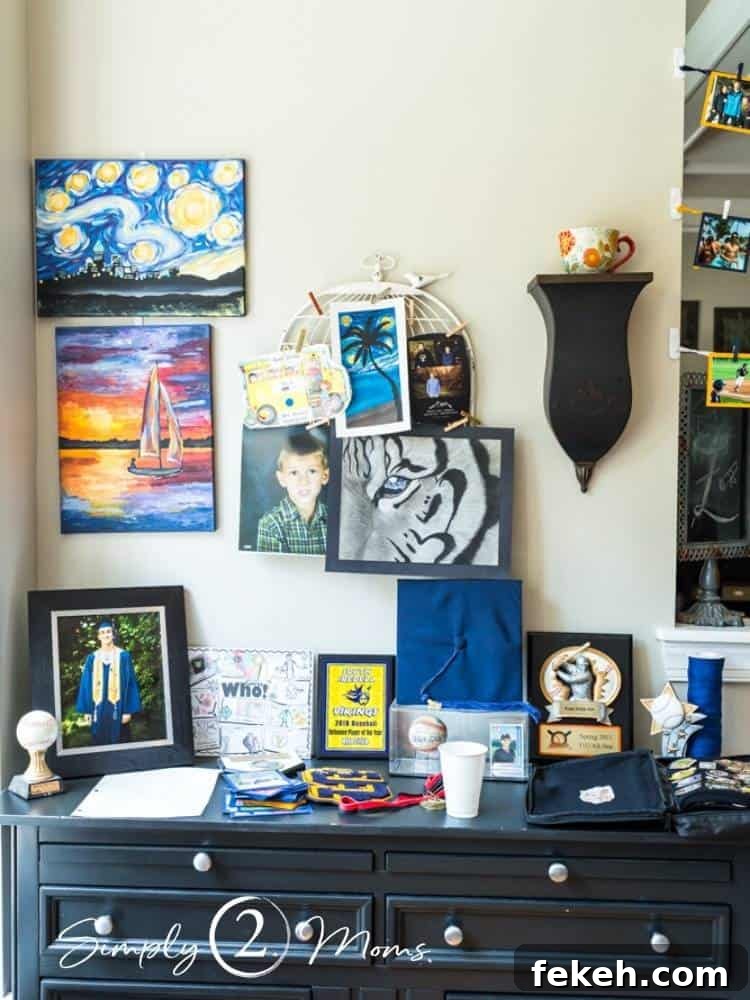 Table holding memorabilia with artwork displayed behind for a graduation party