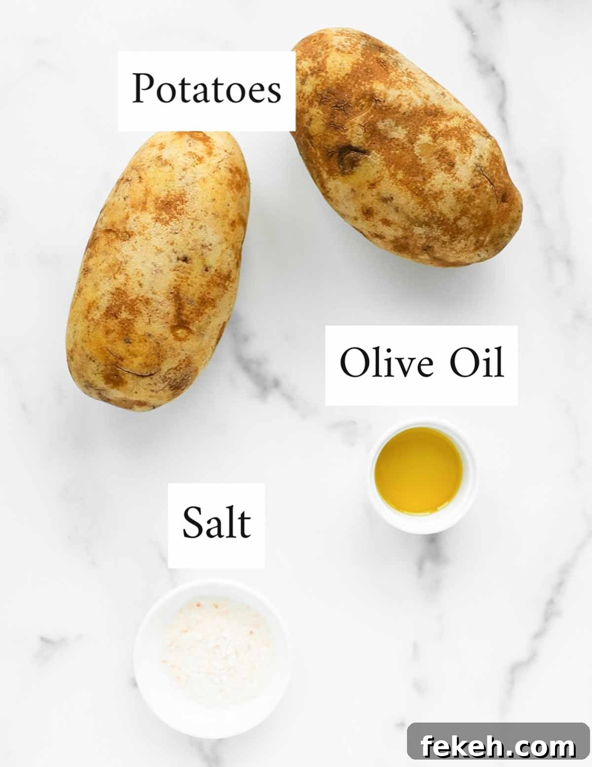 Crispy Air Fryer Baked Potatoes: Quick, Fluffy Centers 3 An overhead image of two potatoes, a small white dish containing olive oil, and a small white dish containing salt