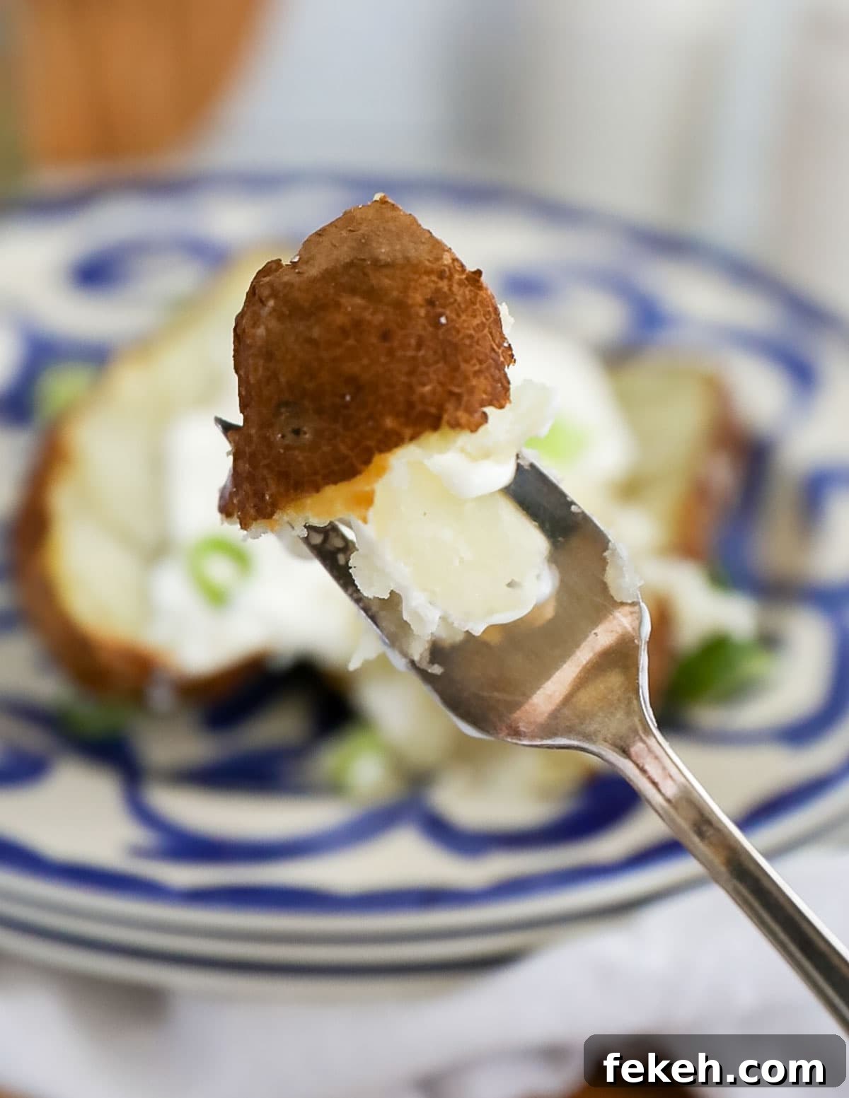 Crispy Air Fryer Baked Potatoes: Quick, Fluffy Centers 5 A fork holding up a bite of cooked russet potato.