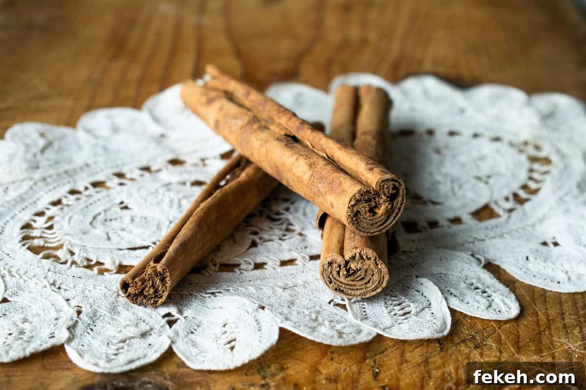 Canela: The Story and Uses of Mexican Cinnamon 3 3 sticks of canela stacked on a white crocheted doilie on top of a wooden work bench.