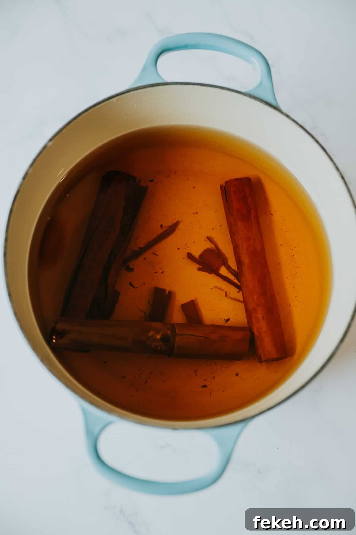 Canela: The Story and Uses of Mexican Cinnamon 4 teal stockpot filled with steeped Mexican cinnamon sticks for canela tea.