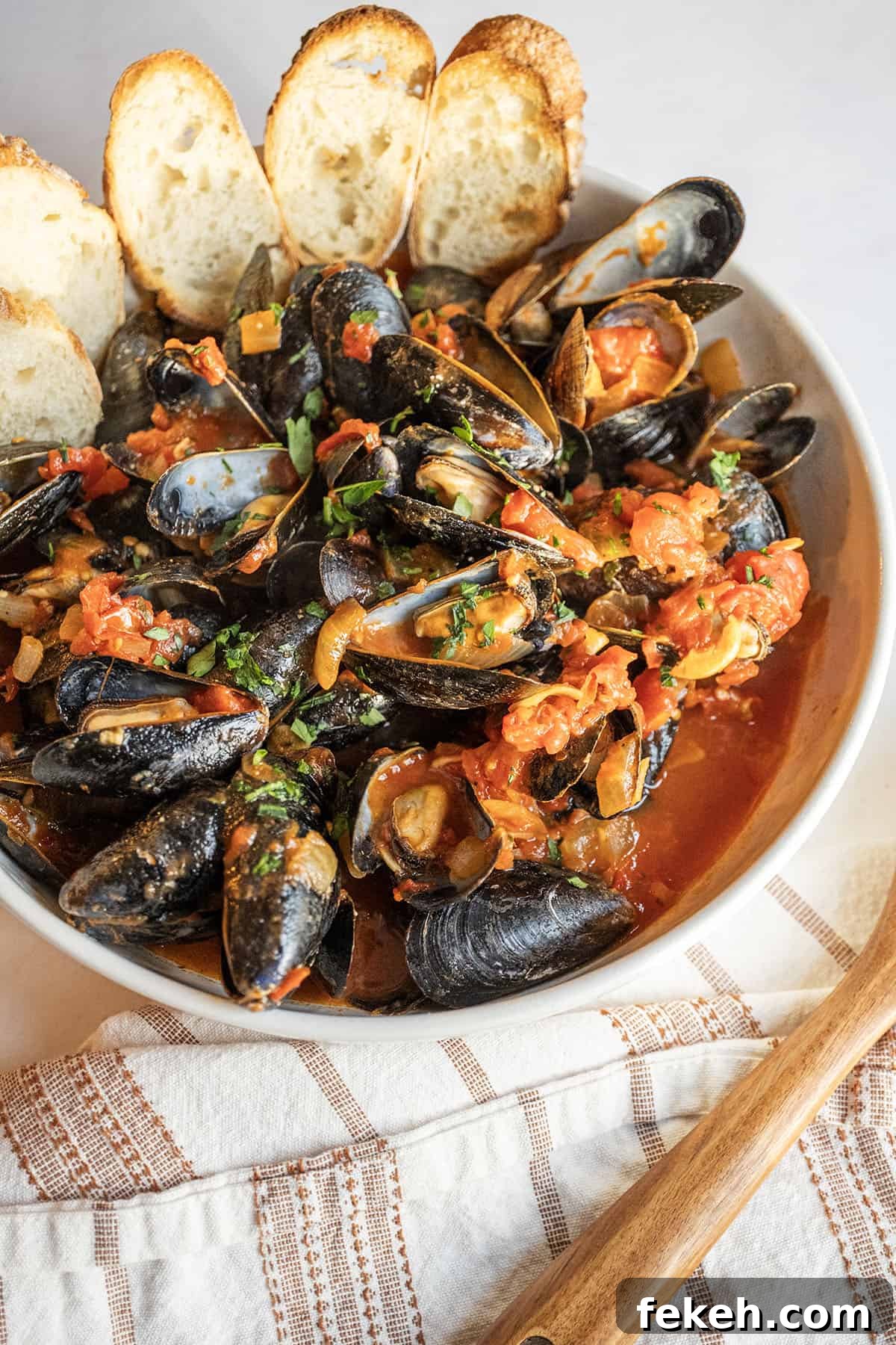 Spicy Mussels Fra Diavolo Recipe: Fiery Tomato & Garlic Stew 2 Mussels Fra Diavolo in a serving bowl with crostini.