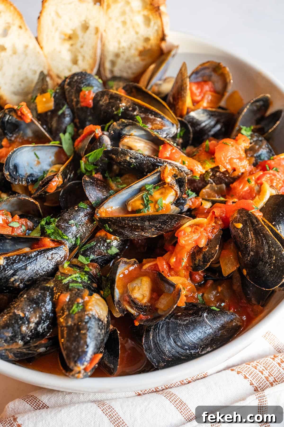 Spicy Mussels Fra Diavolo Recipe: Fiery Tomato & Garlic Stew 10 Mussels Fra Diavolo in a serving bowl with crostini.