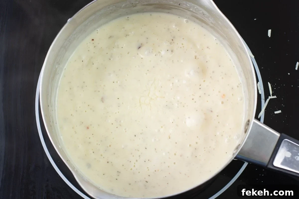 Overhead image of a small pot filled dwith homemade alfredo sauce.