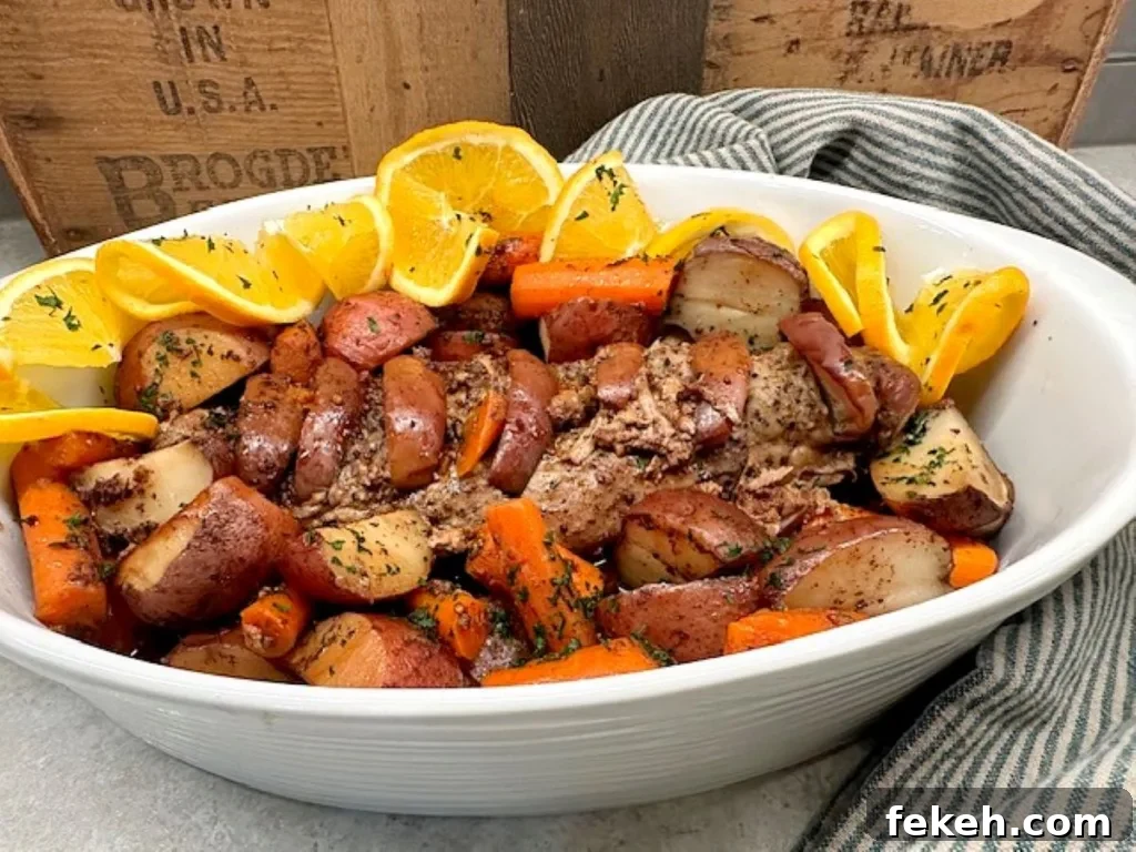 Slow Cooker Pork Tenderloin Recipe the Whole Family Will Love 2 Tender slow cooker pork tenderloin with carrots, potatoes, and orange slices in a white bowl — cozy comfort dinner.