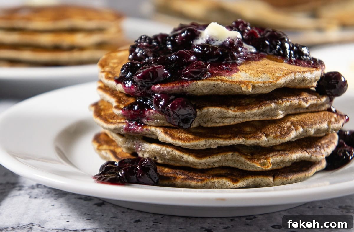 a stack of buckwheat pancakes topped with blueberry compote.