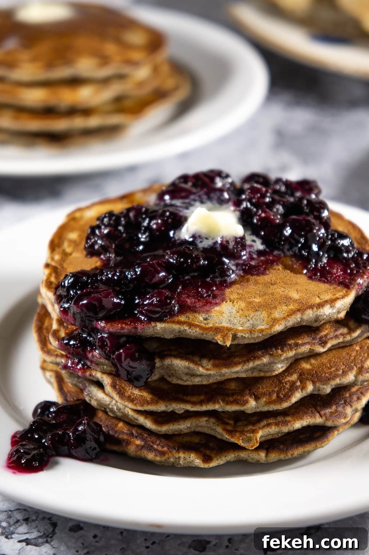 a stack of pancakes with blueberry compote on top.