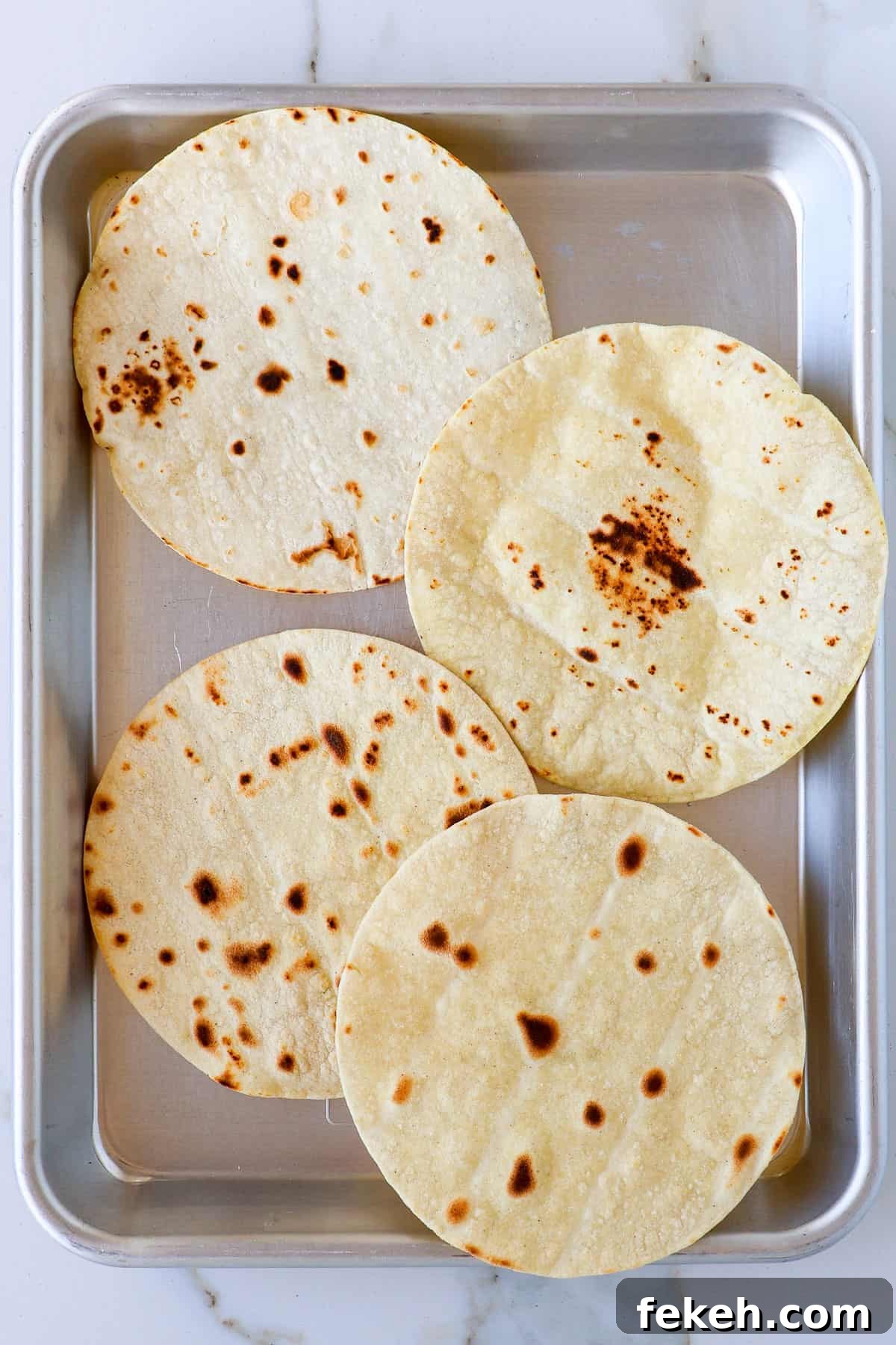 Crispy Chicken Salad Tostadas with Avocado and Lime 5 Toasted tortillas oon a baking sheet.