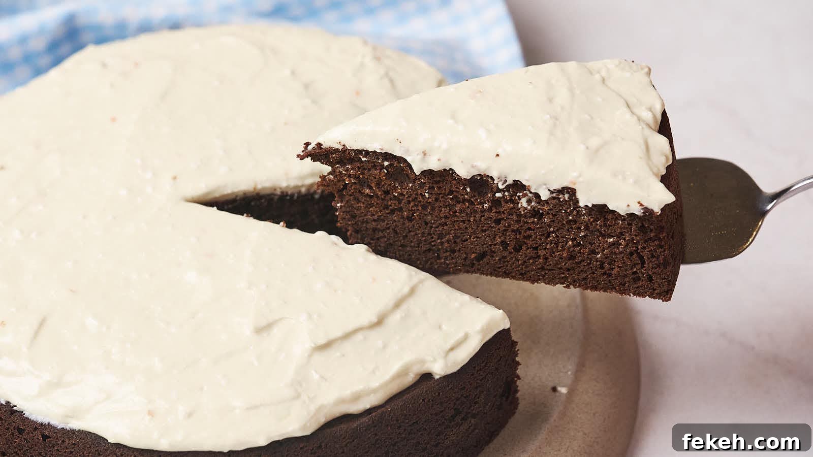 19 Kid-Approved Recipes Kids Beg For (Parents Love Them Too) 5 A slice of chocolate cake with white frosting being lifted from the whole cake.
