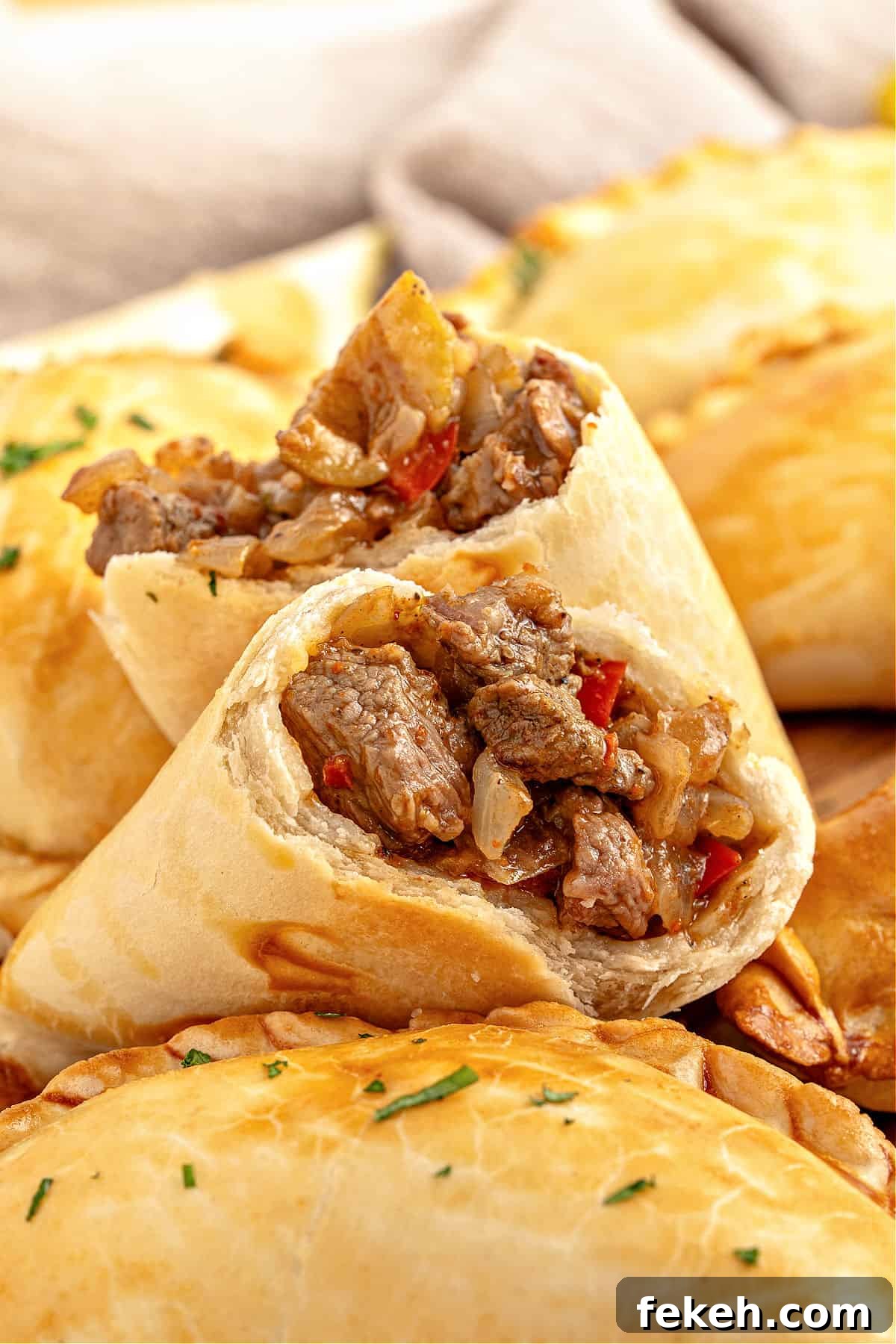 Knife-Cut Beef Empanadas: Crispy Handheld Meat Pastries 2 Halved meat empanada with whole ones.