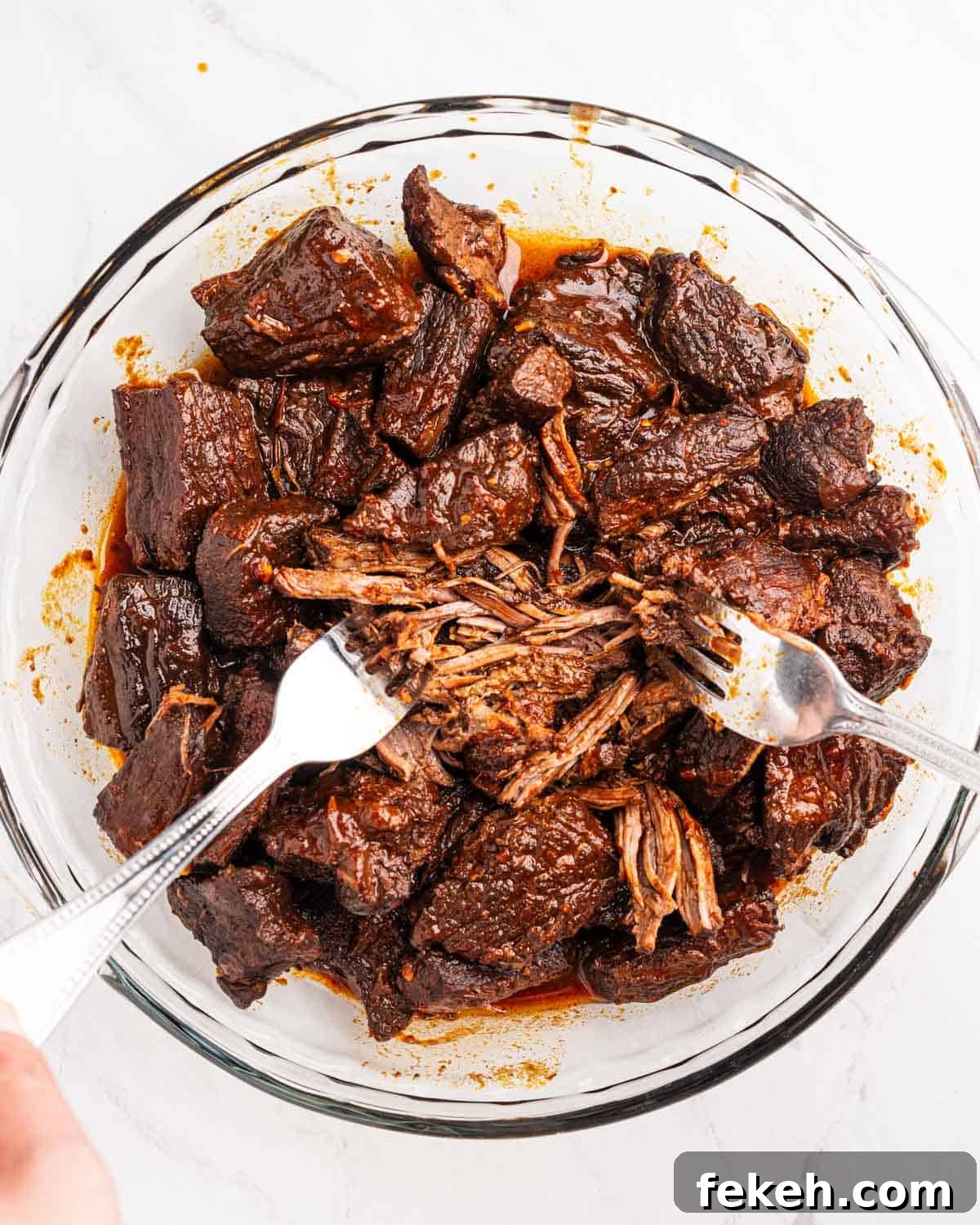 Authentic Quesabirria Tacos: How to Make Birria Tacos at Home 11 Two forks shredding beef.