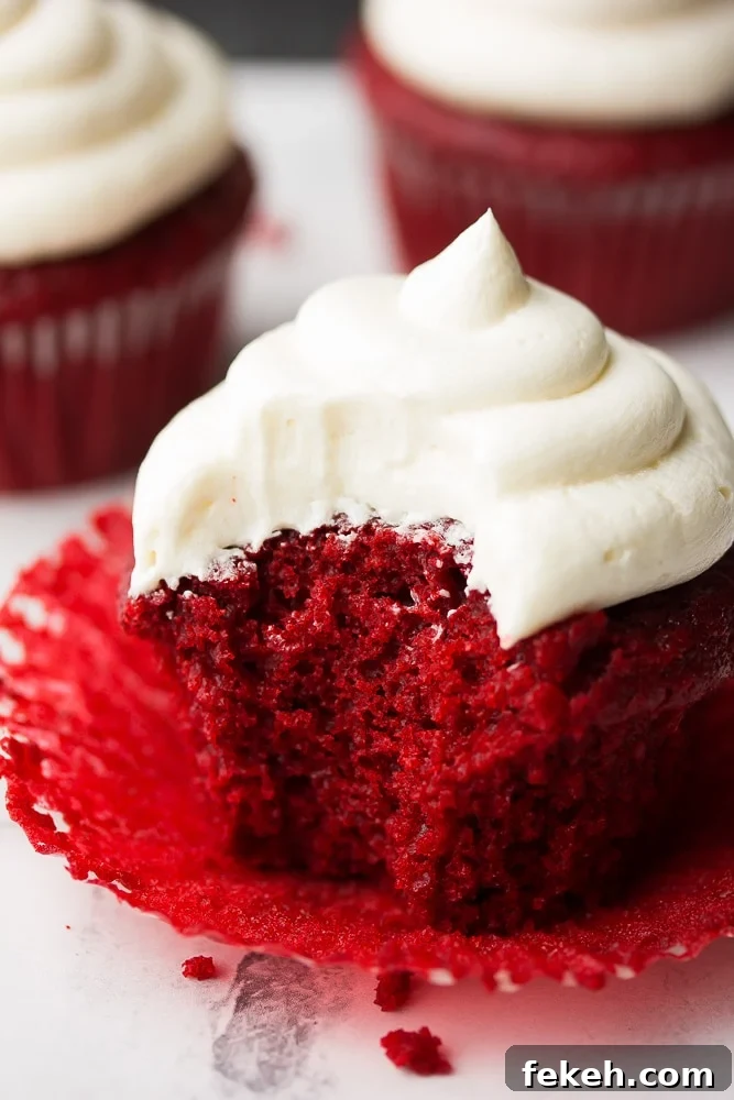Decadent Vegan Red Velvet Cupcakes with Creamy Cashew Frosting 3 bite taken out of cupcake, showing inside