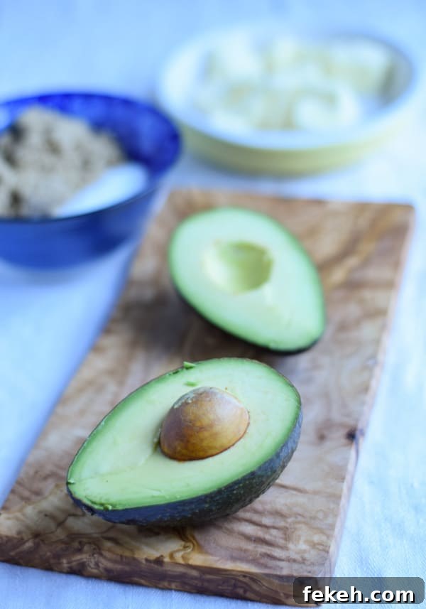 Decadent Chocolate Mint Cookie Recipes for Mint Lovers 3 Avocado cut in half on a wooden board, with other ingredients in the background