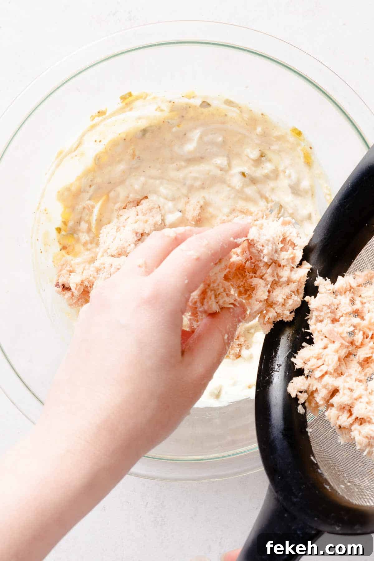 Greek Yogurt Tuna Salad Recipe Without Mayo — High-Protein Lunch 11 drained tuna being added to Greek yogurt dressing in bowl