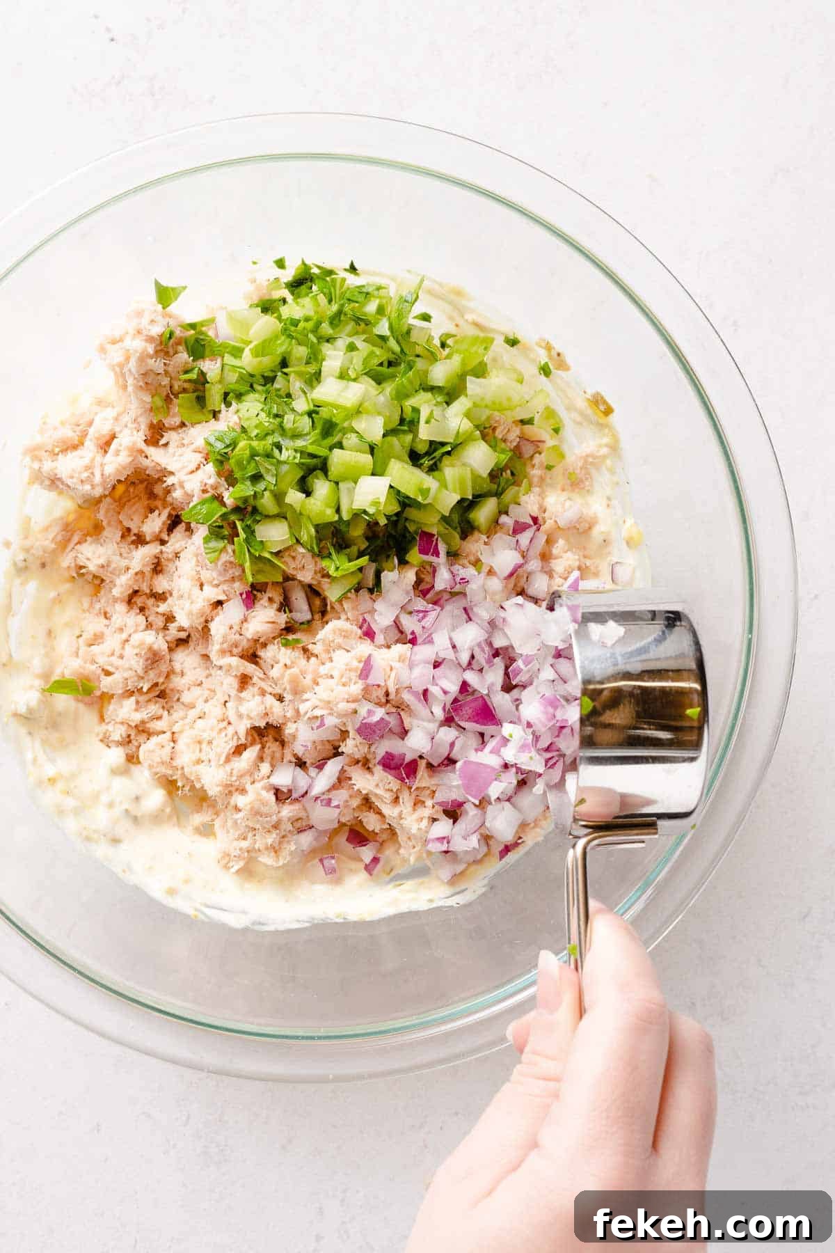 Greek Yogurt Tuna Salad Recipe Without Mayo — High-Protein Lunch 12 celery and onion being added to Greek yogurt tuna salad