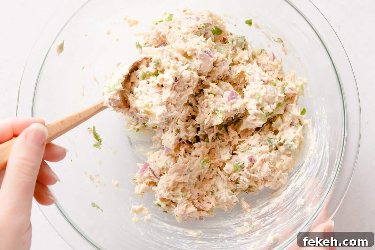 Greek Yogurt Tuna Salad Recipe Without Mayo — High-Protein Lunch 13 Greek yogurt tuna salad being mixed with wooden spoon