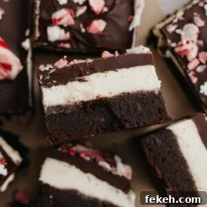 Peppermint Bark Brownies Recipe: Fudgy Chocolate with Candy Cane Topping 16 Peppermint layered brownies on parchment paper.