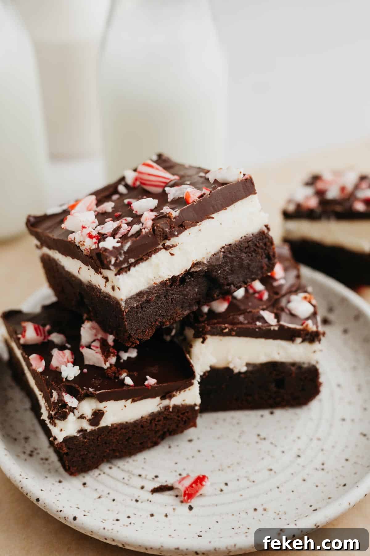 Peppermint Bark Brownies Recipe: Fudgy Chocolate with Candy Cane Topping 10 A stack of layered peppermint bark brownies on a small plate.