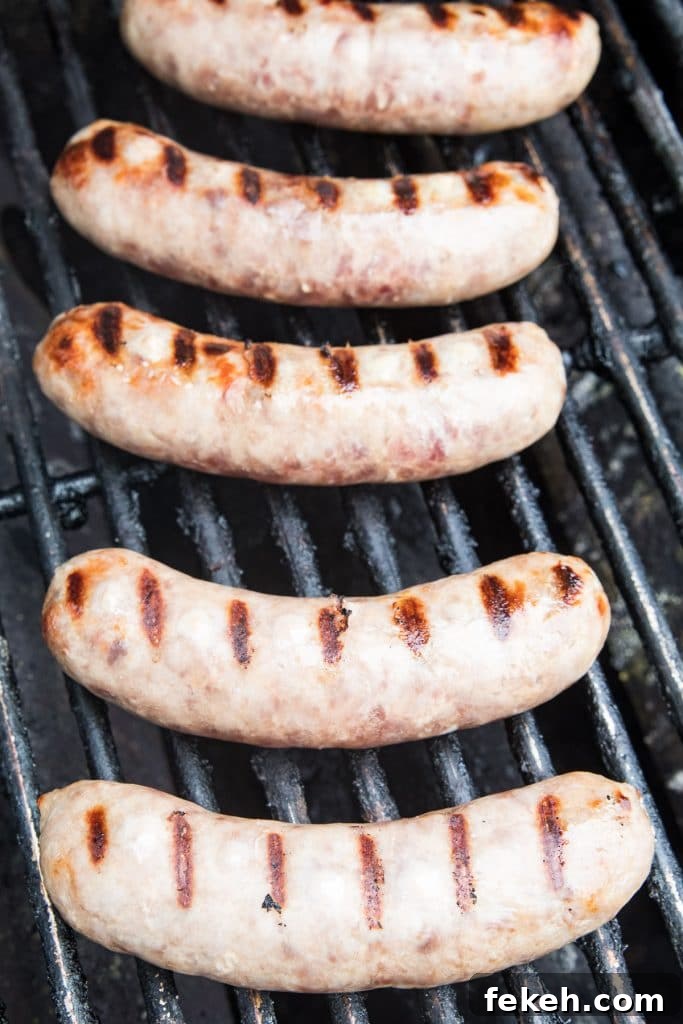 Spicy Chili Cheese Bratwurst Sandwiches for Game Day 4 Brats on grill grates with sear marks.