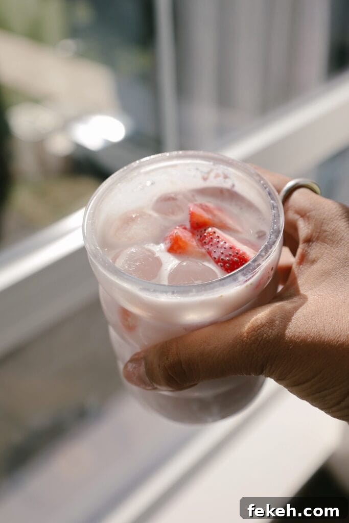 Strawberry Agua Fresca with Creamy Mexican Crema 2 hand holding glass with drink