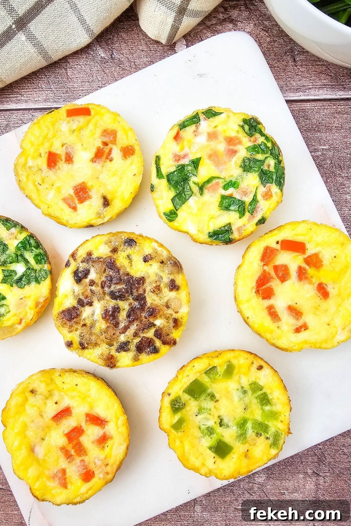 Dairy-Free Gluten-Free Egg Bites Recipe for Meal Prep 2 Mini dairy-free egg bites with bell peppers in them on a white plate.
