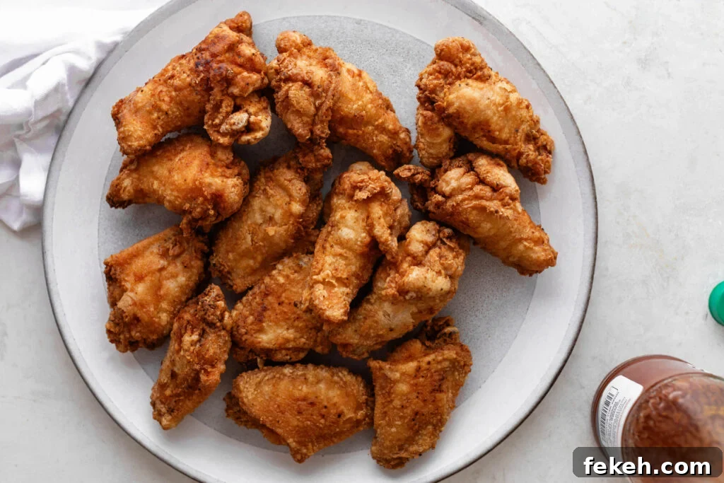 Crispy Southern Fried Chicken Wings Recipe for Perfect Crunch 4 southern fried chicken wings on a white and gray plate