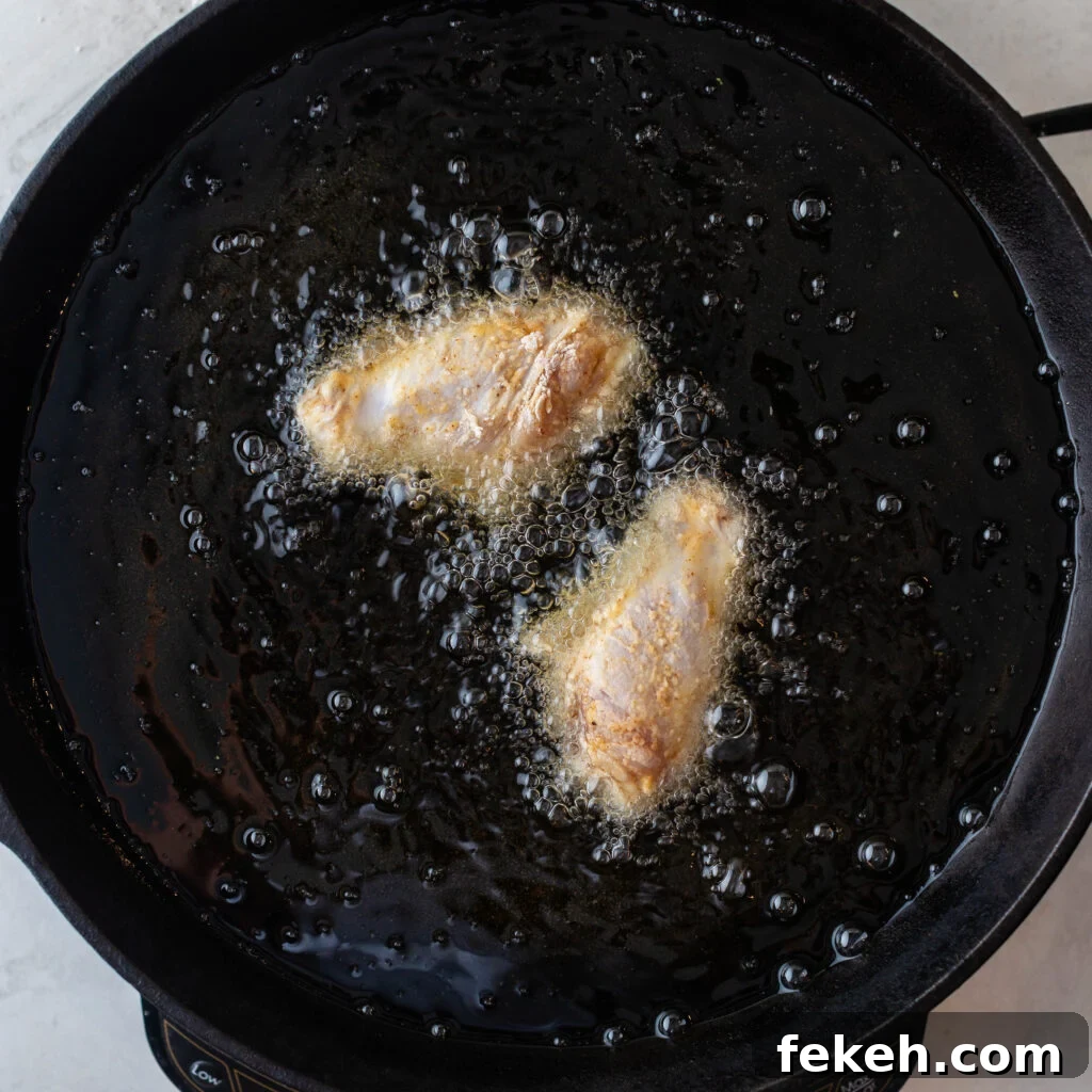 Crispy Southern Fried Chicken Wings Recipe for Perfect Crunch 8 2 chicken wings frying in a cast iron skillet
