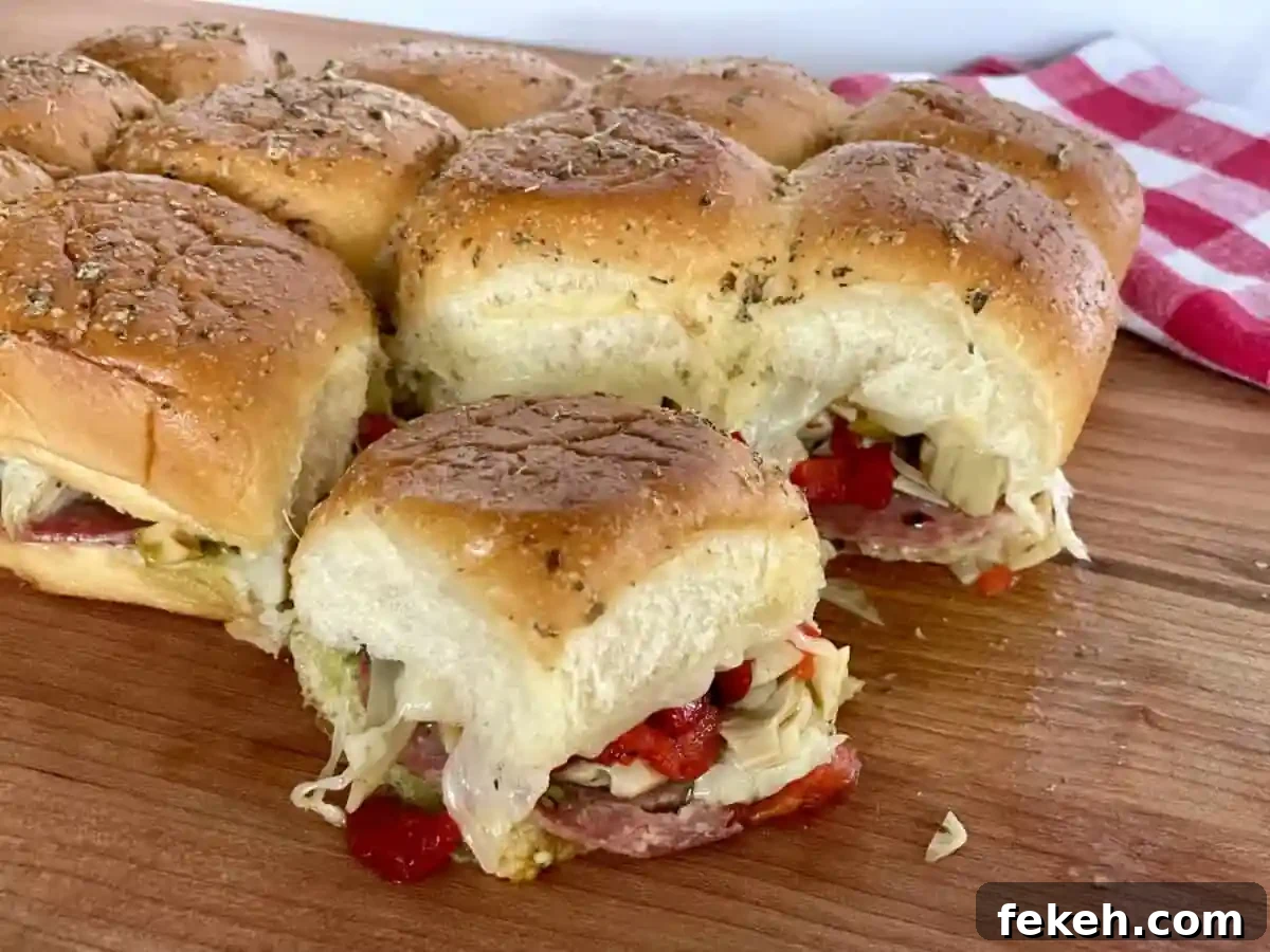 Antipasto Sliders on King's Hawaiian Rolls: Italian Sandwich Recipe 2 Antipasto Sliders on a wooden cutting board.