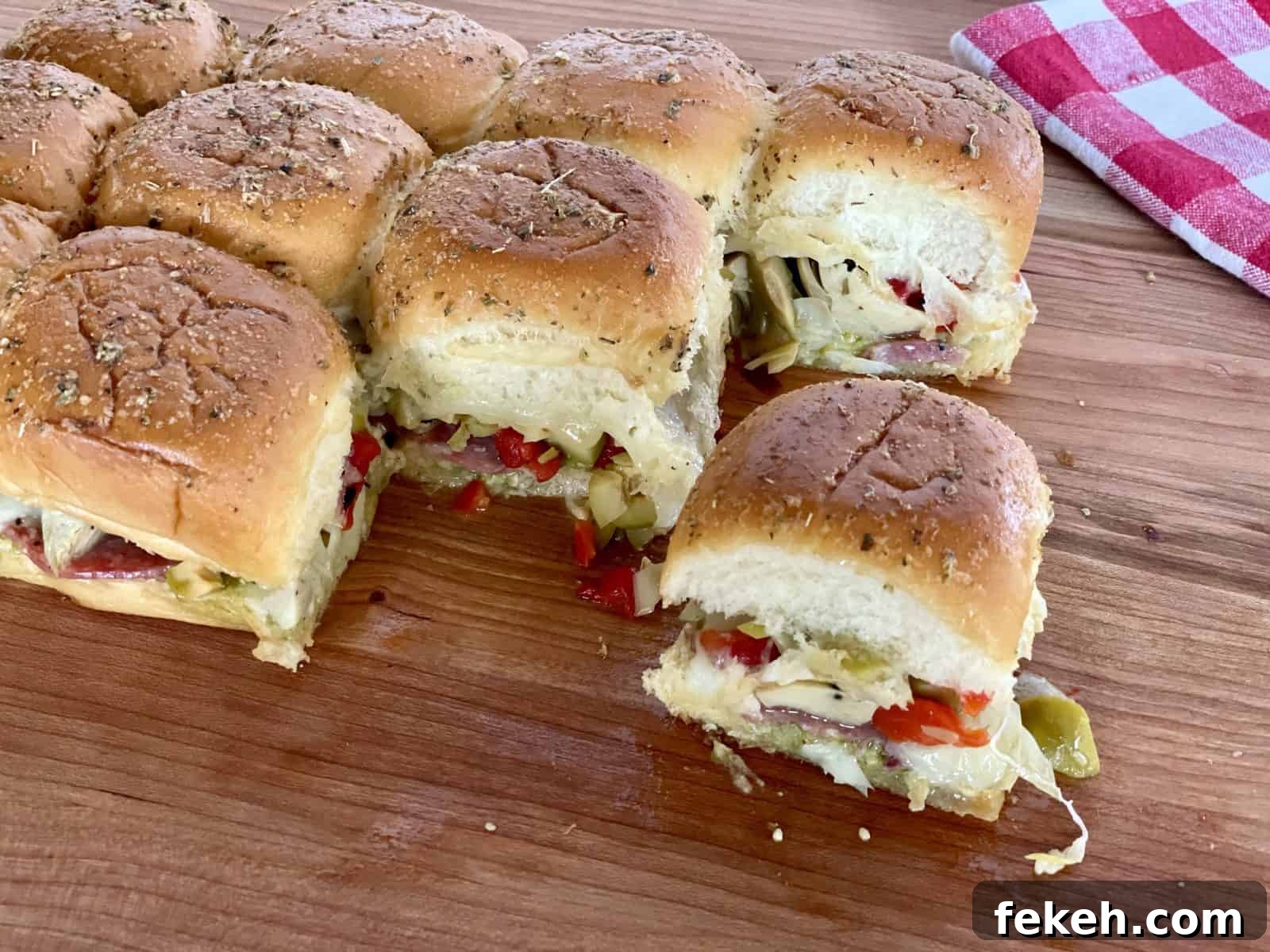 Antipasto Sliders on King's Hawaiian Rolls: Italian Sandwich Recipe 9 Antipasto Sliders on a wood cutting board.