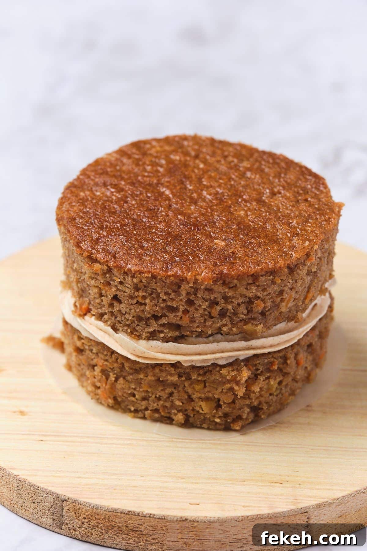 Moist Mini Carrot Cake Bites: Perfect Party Cupcakes 11 two small carrot cake layers with cinnamon buttercream in between the layers.