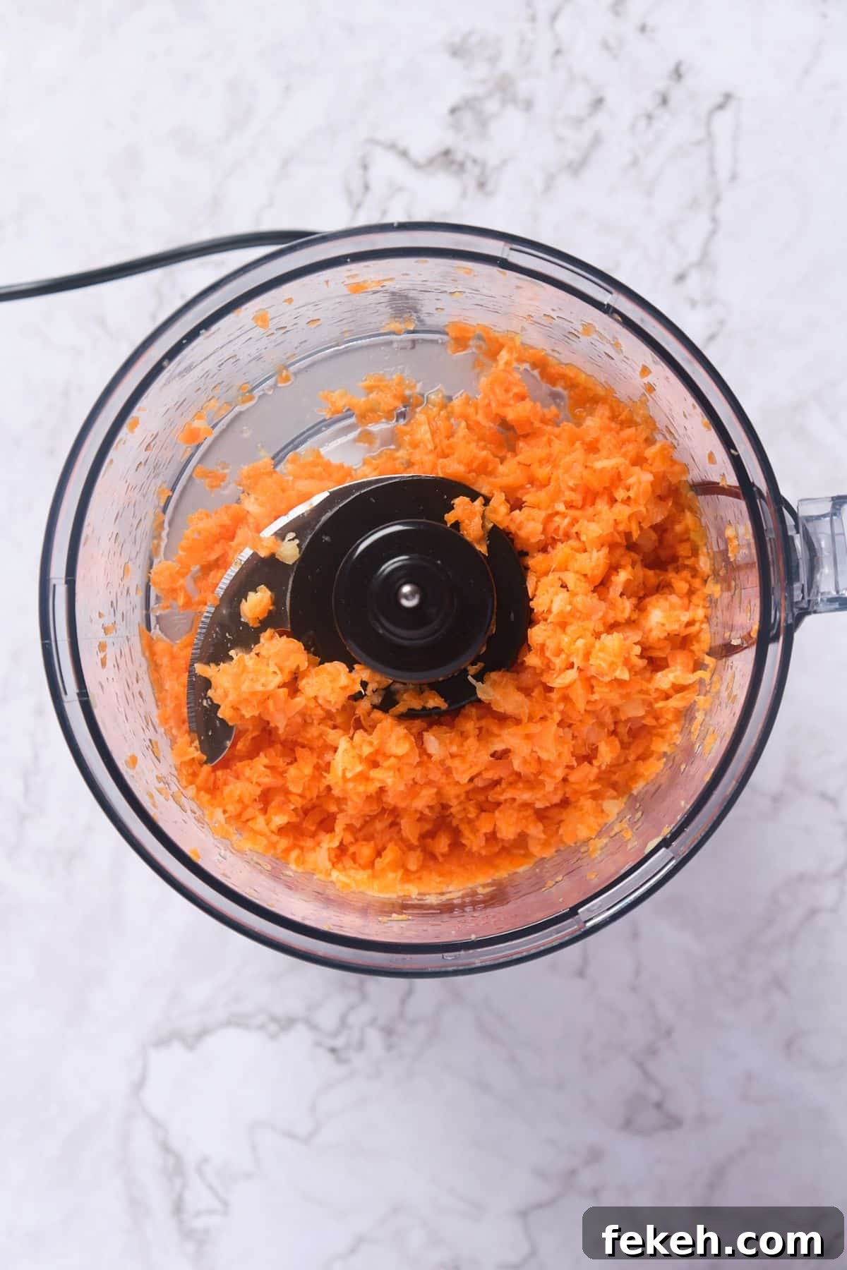 Moist Mini Carrot Cake Bites: Perfect Party Cupcakes 5 mini carrots and crushed pineapple being processed in a food processor.