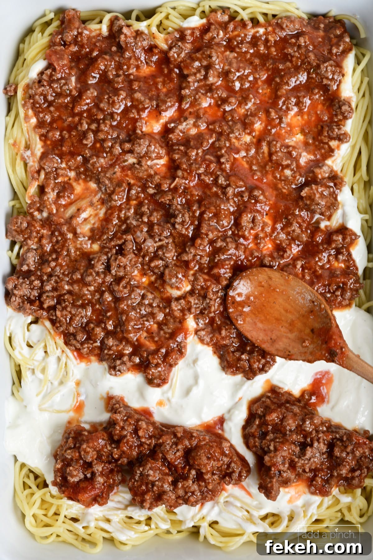 Cheesy Baked Spaghetti Casserole Recipe for Weeknight Dinners 9 Layering million dollar spaghetti casserole in a baking dish.