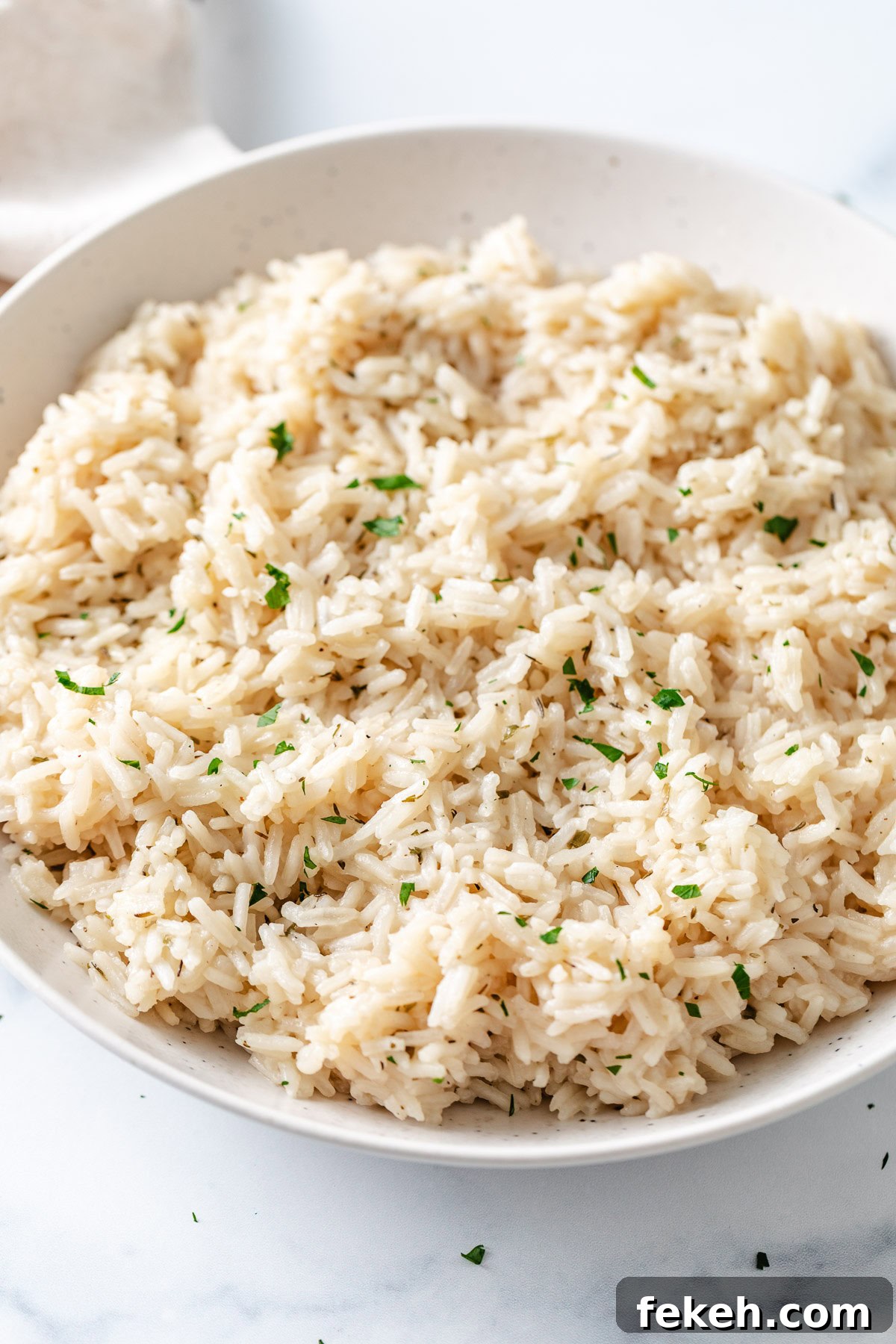 Herb rice in a speckled dish.