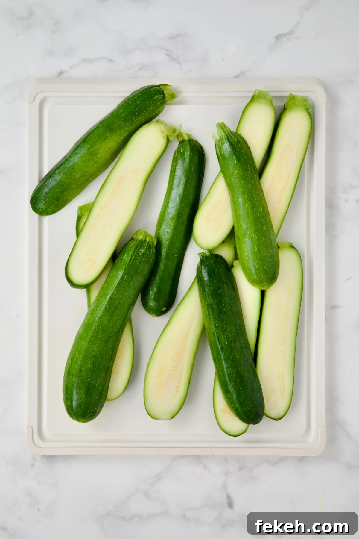Mediterranean Grilled Zucchini with Dill Yogurt & Feta 6 Sliced zucchini on white plastic cutting board.