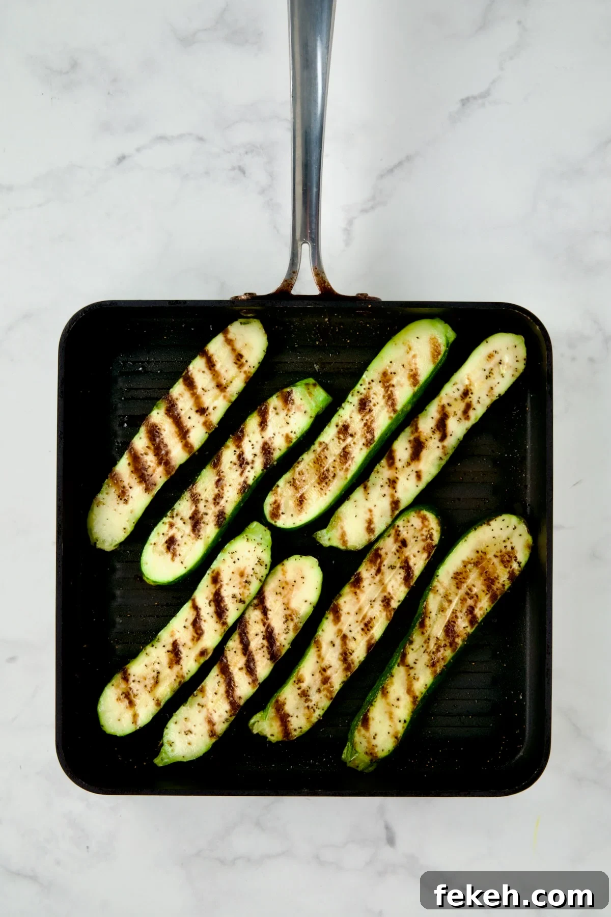 Mediterranean Grilled Zucchini with Dill Yogurt & Feta 8 Eight grilled zucchini slices on square grill pan.