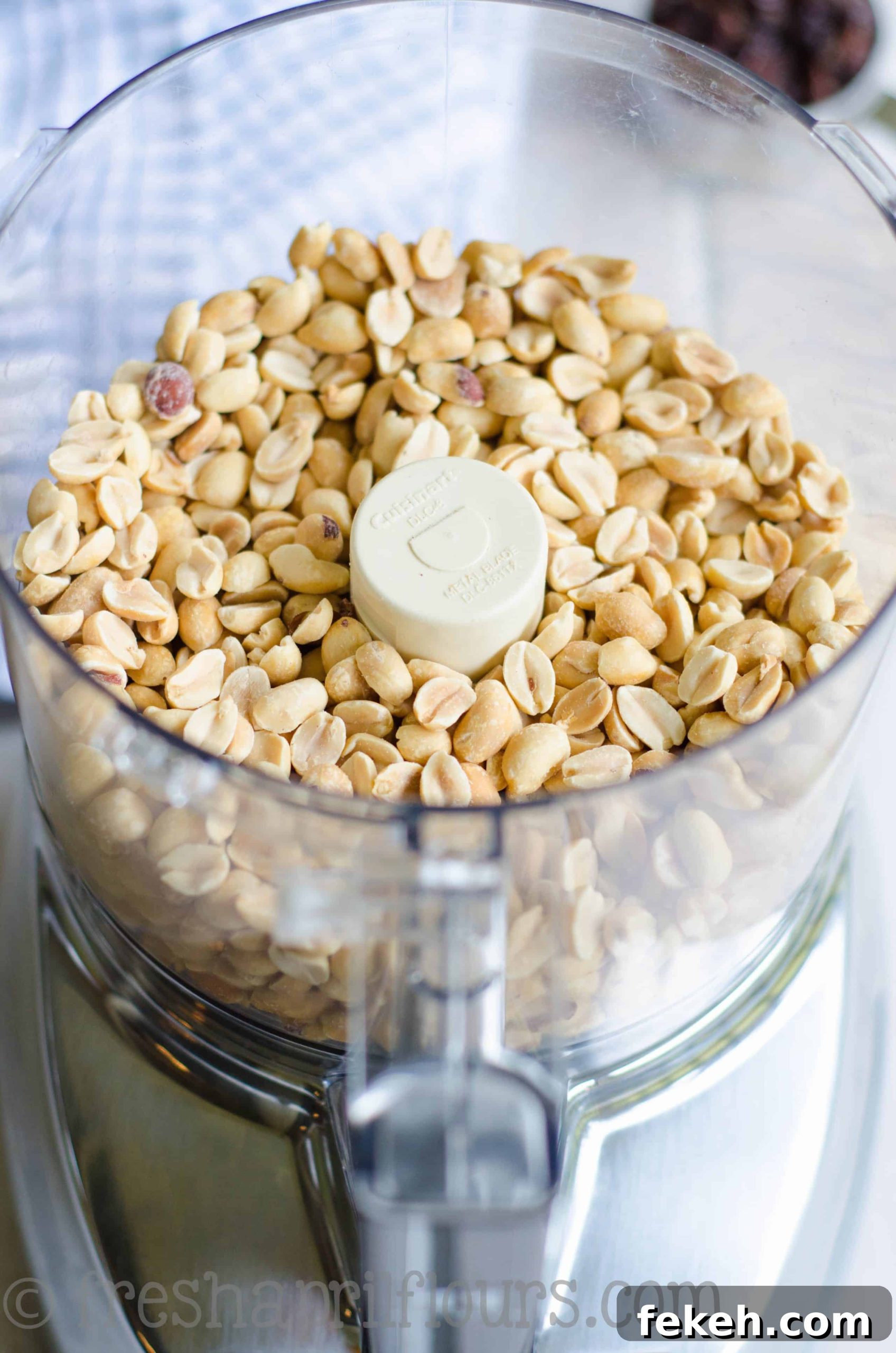 peanuts in the bowl of a food processor to make homemade cinnamon raisin peanut butter