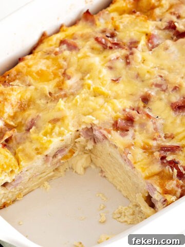 Bread pudding with ham and cheese in a rectangular baking white dish. Serving missing.