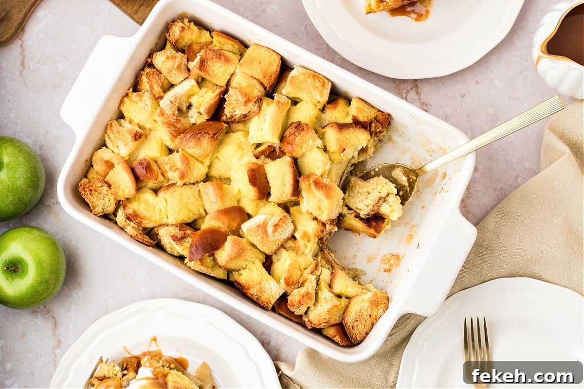 Rectangular white dish with apple bread pudding. White plates, apples. White background.