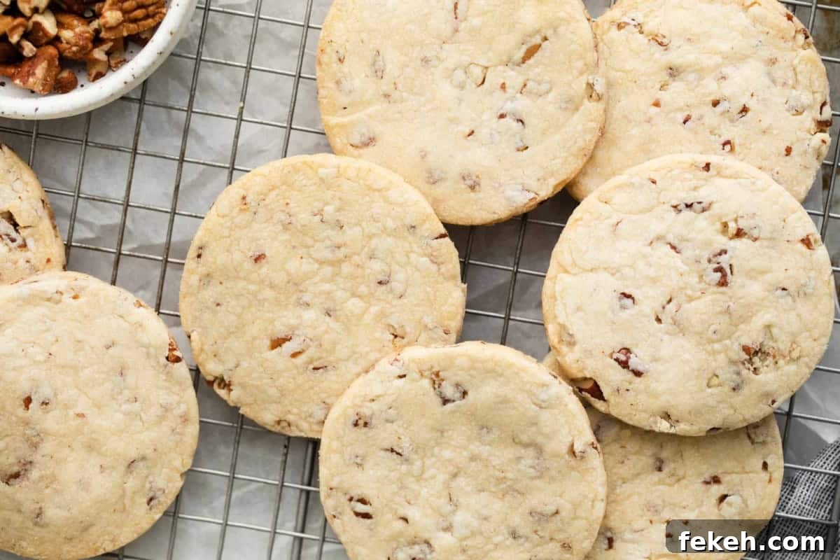 overhead view of freshly baked pecan shortbread cookies on a wire rack.