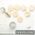 cut out pecan shortbread cookies on a floured cutting board.