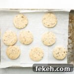 freshly baked pecan shortbread cookies on a lined baking sheet.
