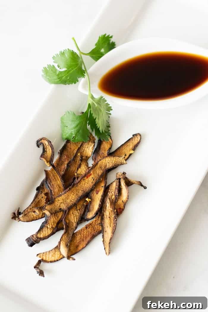 Mushroom jerky on white plate with green garnish and soy sauce in small dish