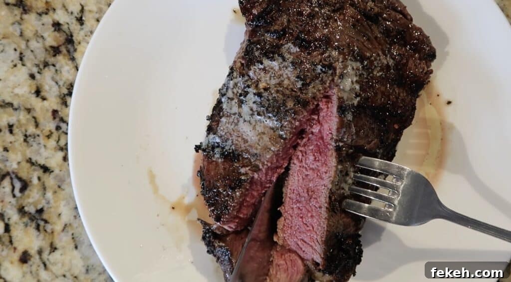 Slicing into the center of the steak to reveal a juicy medium-rare, pinkish-red center