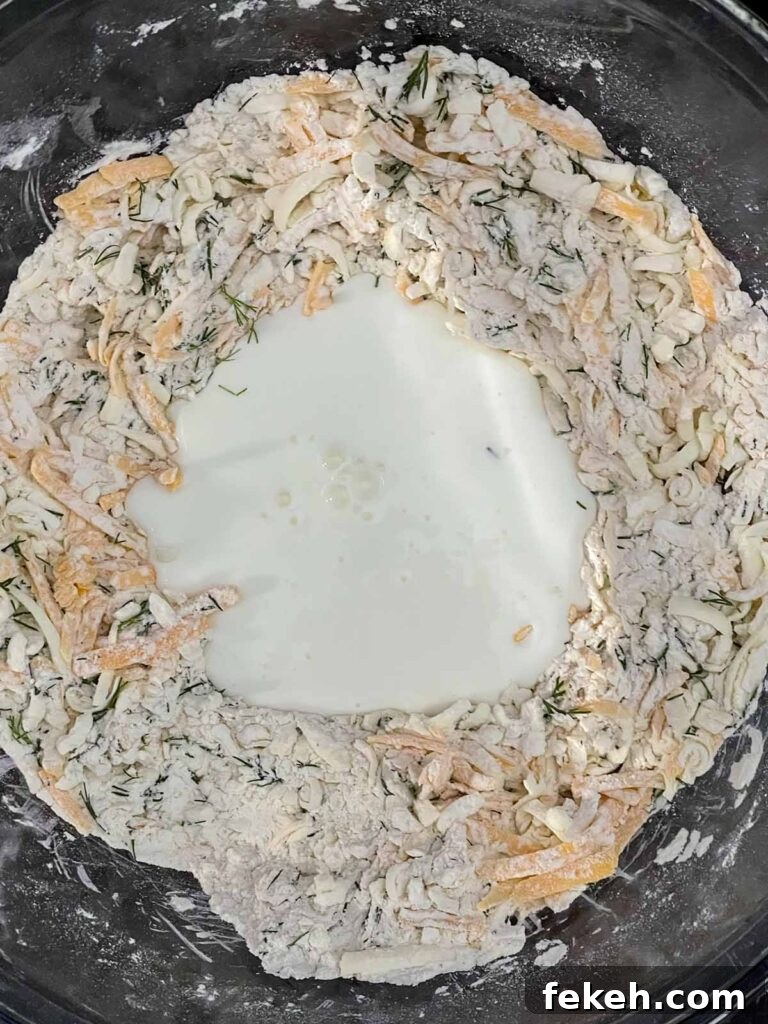 Buttermilk poured into the well of the biscuit dough ingredients.
